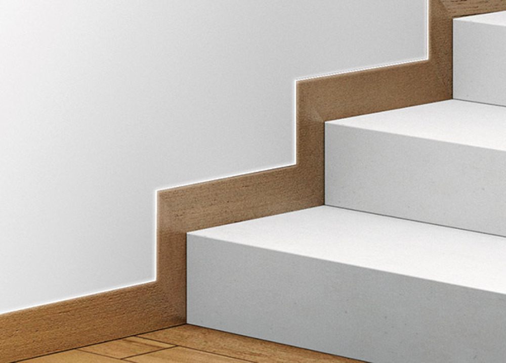 Fußleistenprofil PLANO SL von Eclisse im Treppenaufgang mit Lichteinsatz und montierter Fußleiste aus Holz